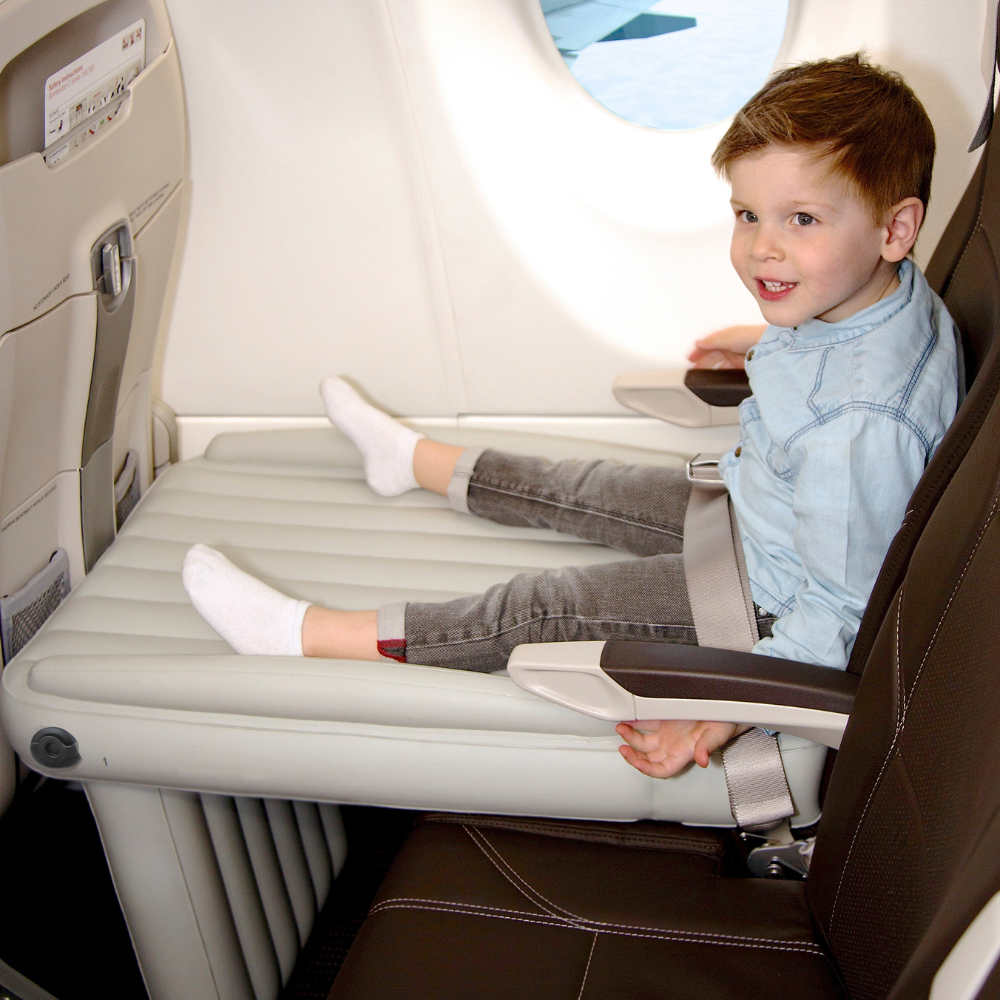 Child sitting on Flyaway Kids Bed inflatable airplane bed
