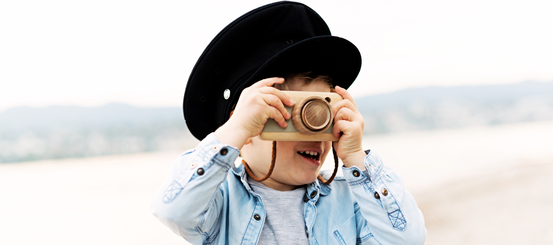 child holding camera