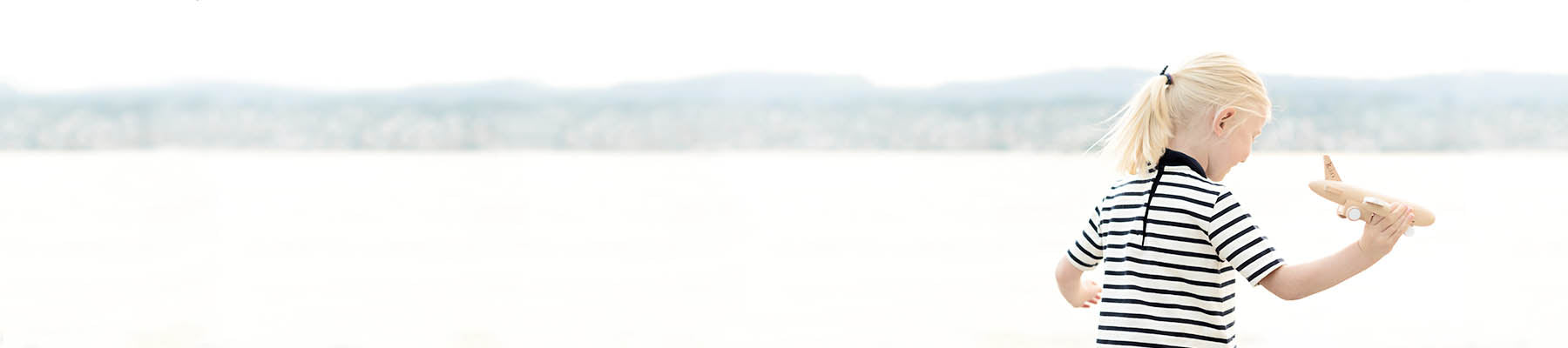 Girl running with airplane pretending to fly